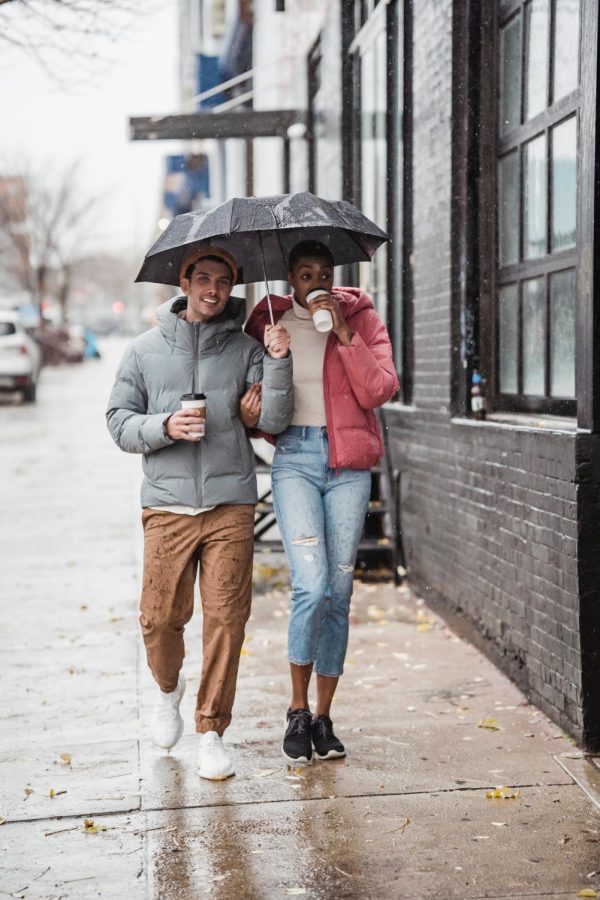 Happy couple walking on the street on a rainy day