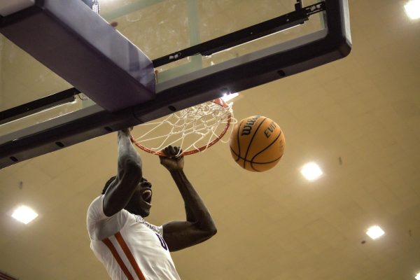 Senior forward Lado Laku dunks against John Melvin University in home game. 