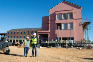 Ninel Kovacs (left) and Dale Wohletz (right) pose in front of Alost Hall as it undergoes construction.