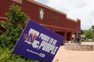 Local businesses show their support for NSU by displaying "Proud to be Purple" signs.