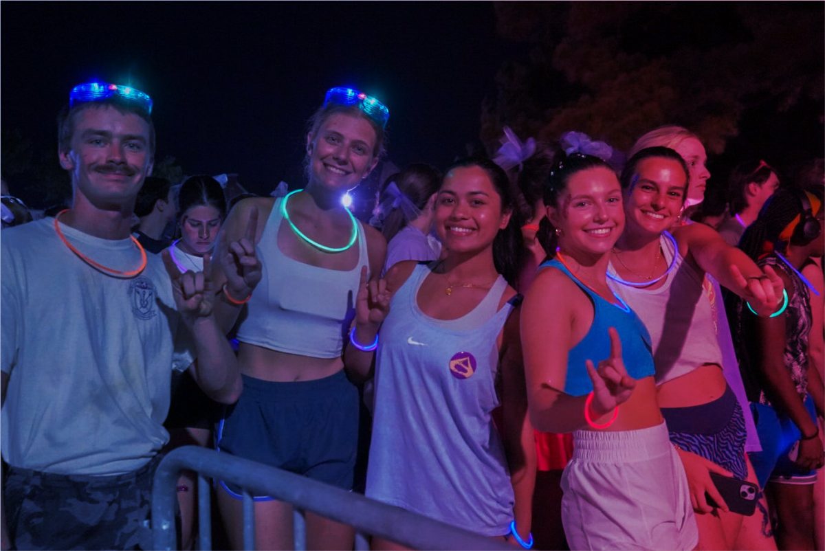 Students wear glow sticks and sports wear as they prepare for the homecoming fun run.